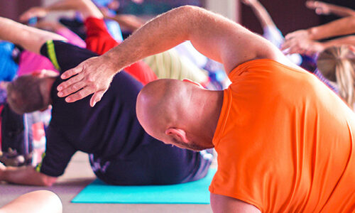 image of a fitness class sat on the floor stretching in unison by Anupam Mahapatra via unsplash.com